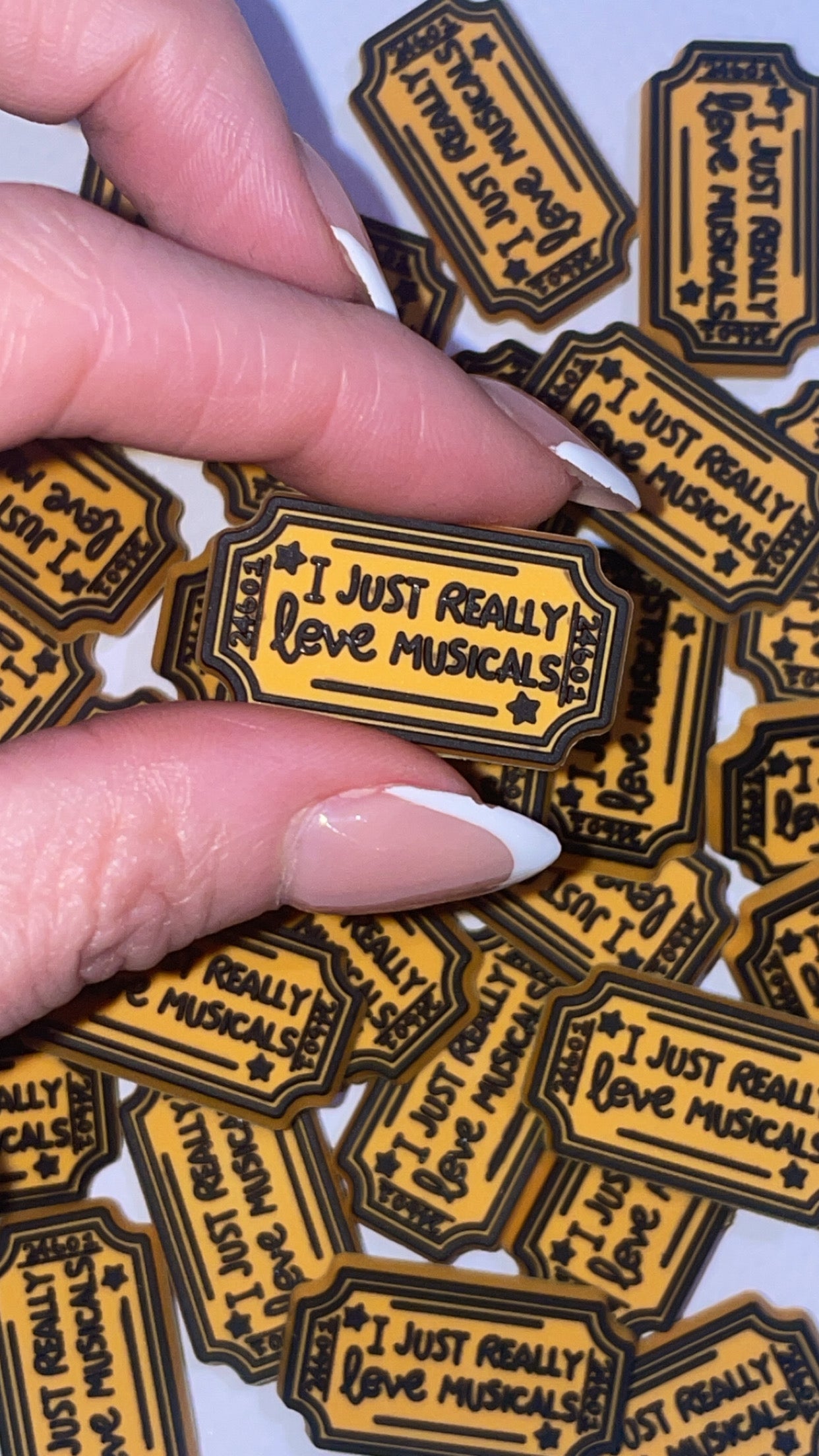 Musical theatre-themed Croc charms set with masks, notes, and microphone designs”
“Broadway-inspired Croc charms on black and gold Crocs shoes”
“Theatre and music Croc charms flat lay – spotlight, ticket, and mask designs”
“Drama and performance Croc charms gift set for theatre lovers”
“Stage-themed Croc charms with glitter and gold accents”