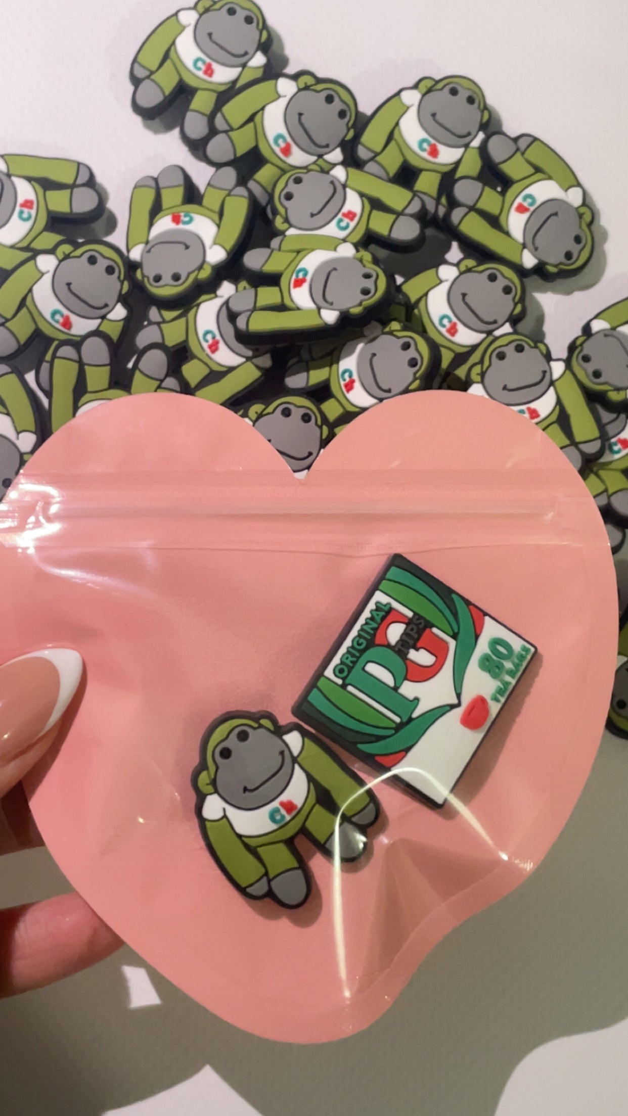 Cheeky tea-loving monkey Croc charms set with tea cup and biscuit designs”
“British-inspired Croc charms on brown and beige Crocs shoes”
“Monkey and tea Croc charms flat lay – cozy cuppa theme”
“Funny UK-themed Croc charms set with biscuits and cartoon monkeys”
“Tea and monkey Croc charms gift set – cozy and cheeky style”