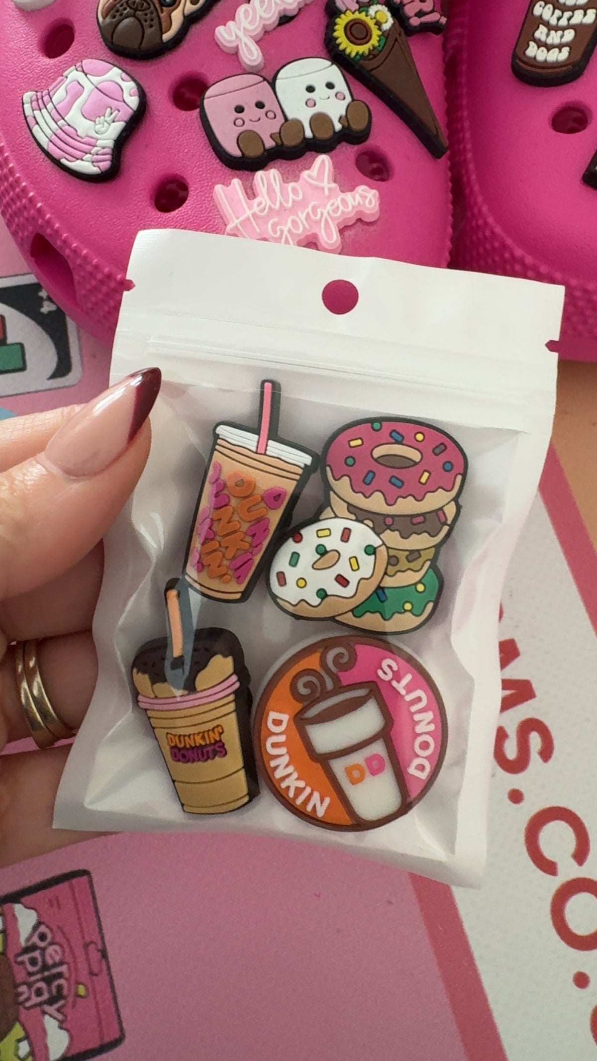 Four coffee and doughnut Croc charms featuring a pink iced drink, colourful doughnuts, coffee cup and coffee-shop inspired logo design.