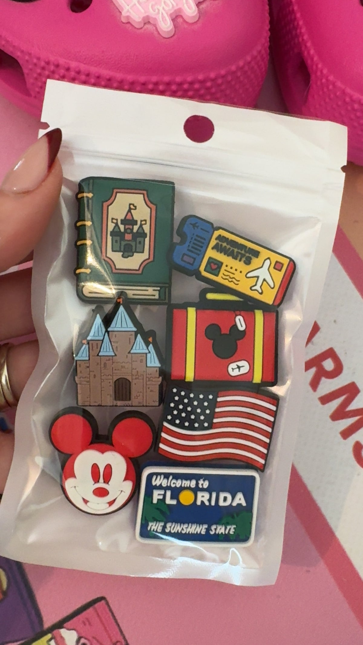 Pink suitcase travel shoe charms featuring a castle and airplane ticket