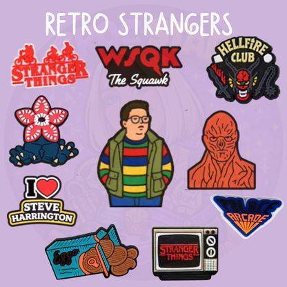Set of retro 80s mystery inspired croc charms featuring arcade, creature, and vintage TV style designs on a purple background