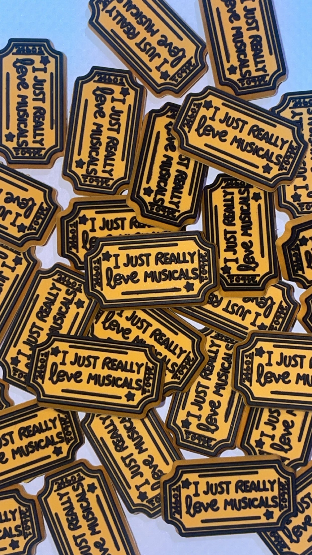 Musical theatre-themed Croc charms set with masks, notes, and microphone designs”

“Broadway-inspired Croc charms on black and gold Crocs shoes”

“Theatre and music Croc charms flat lay – spotlight, ticket, and mask designs”

“Drama and performance Croc charms gift set for theatre lovers”

“Stage-themed Croc charms with glitter and gold accents”